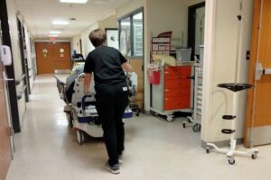 A medical professional pushing a patient on a gurney, Covid-19 Wrongful Death Liability