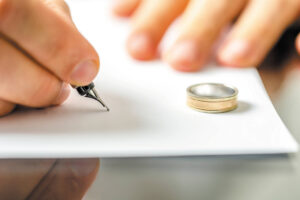 A fountain pen next to a wedding ring, symbolizing a divorce agreement.