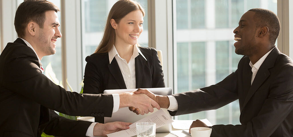 Handshake sealing a purchase and sale agreement involving license transfers in Massachusetts.