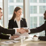 Handshake sealing a purchase and sale agreement involving license transfers in Massachusetts.