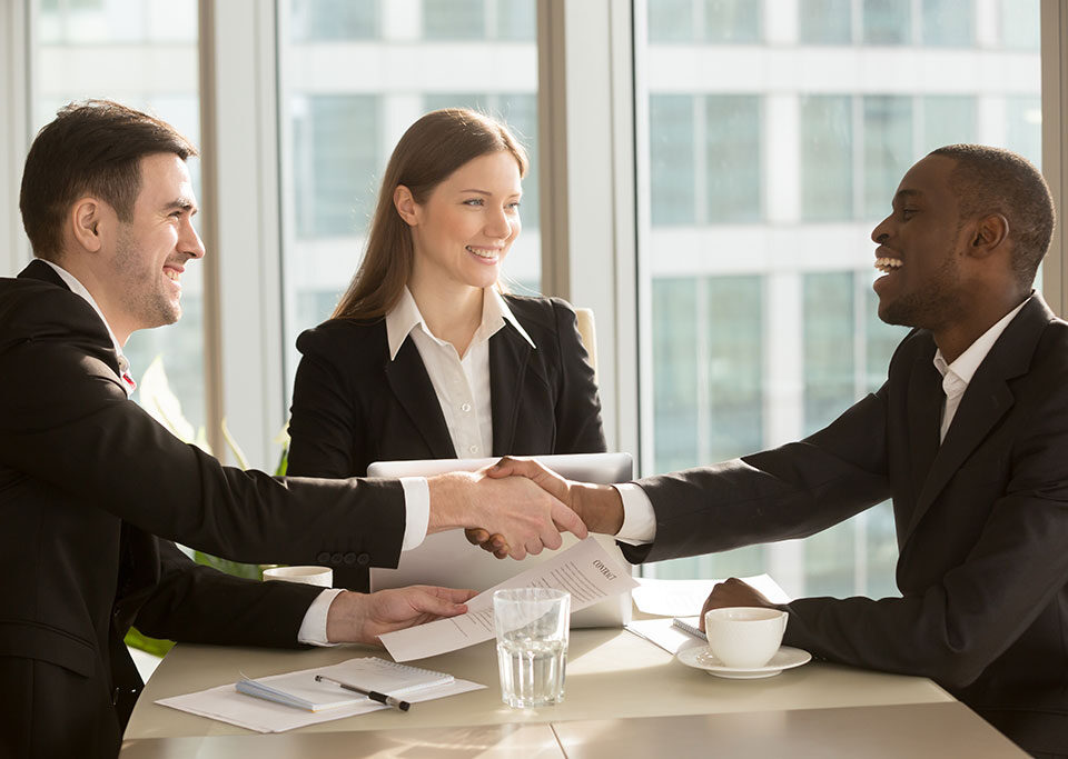 Handshake sealing a purchase and sale agreement involving license transfers in Massachusetts.
